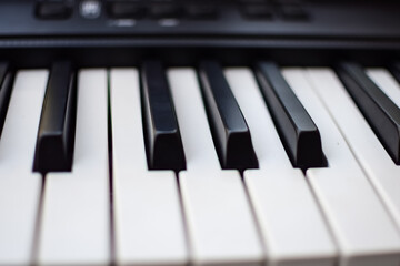 Fototapeta premium Close-up of piano keys. Piano black and white keys and Piano keyboard musical instrument placed at the home balcony during sunny day.