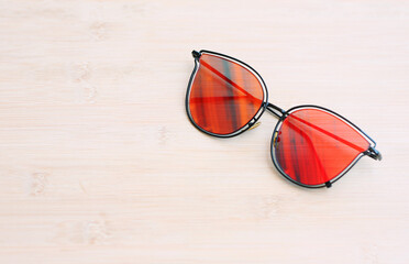 Orange mercury glasses reflect light top view close-up photo space copy space.