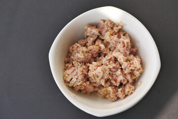 canned tuna in a white bowl on table 