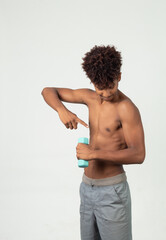 Fototapeta premium Muscular latin adolescent , teen showing his arm holding a dumbbells looking to the camera doing exercises with dumbbells isolated over white background