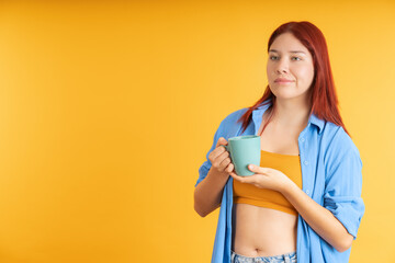 Young redhead woman drinking a cup of coffee