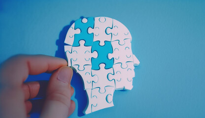 Human hand is complete Jigsaw puzzle as a human head shape on blue background for Alzheimer day or for brainstorm to drive a business ,Generative AI