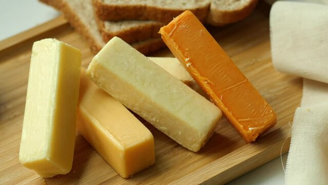Cheese cubes green, yellow and red color on chopping board 