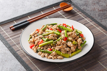 Delicious fried minced pork with asparagus, garlic, chili and sesame close-up in a plate on the table. Horizontal