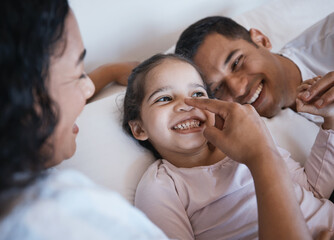 Love, smile and happy family in a bed laughing, bonding and playing in their home together. Face, playful and girl child with parents in a bedroom, having fun and enjoying a weekend in their house