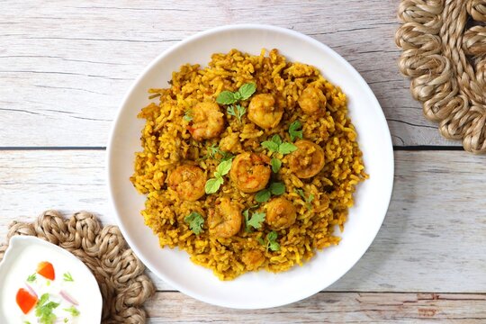 Prawns Biryani or shrimp Pulao. also called jheenga pilaf or jhinga biryani in India. known as Kolambi bhat in Marathi. Garnished with mint leaves, and coriander along with yogurt Raita. Copy space