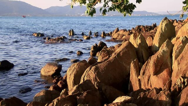 Ambient motion of the dreamy gentle waves lapping at the rocks in Koh Tonsay or Rabbit Island in Cambodia
