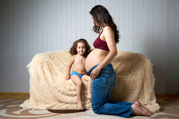 Beautiful pregnant woman with cute daughter