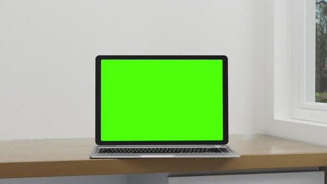 Empty green screen display Laptop turn and open in a minimal white wall Background. There was light from the windows at different times. 3D rendering