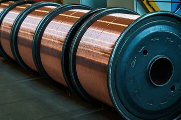 Huge reels with shiny copper wire in factory warehouse