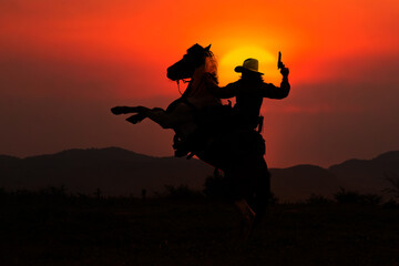 Silhouette of cowboy on horseback and sunset as background - 608909189