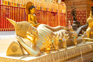 Fototapeta premium Golden reclining Buddha statue in Thai temple