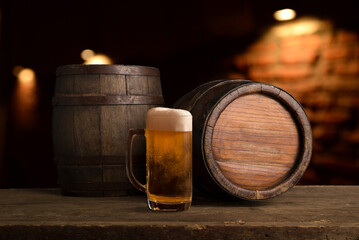 mug of beer, wheat ears, green hops and beer barrel on a wooden background. High quality photo