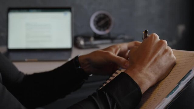 showcases a high-quality close-up shot of a professional man engaged in the act of writing. Shot in crisp detail and excellent composition, this video is perfect for various creative projects.