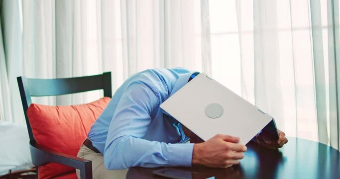 Embarrassed Businessman Hiding Under Laptop