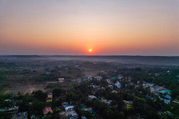 Fototapeta premium Aerial view of mountain peak and sea and sunset colorful sky from above from drone