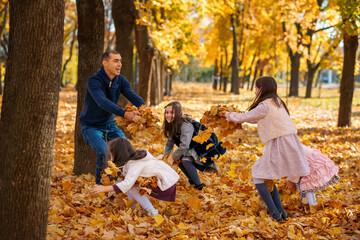 portrait of a large family with children in an autumn city park, happy people playing together and throwing yellow leaves, beautiful nature, bright sunny day