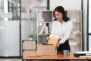 Resignation concept. Fired employee holding box of belongings in an office