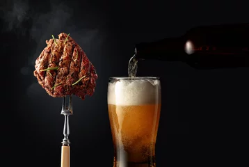 Zelfklevend Fotobehang Grilled ribeye beef steak with rosemary and glass of beer. © Igor Normann