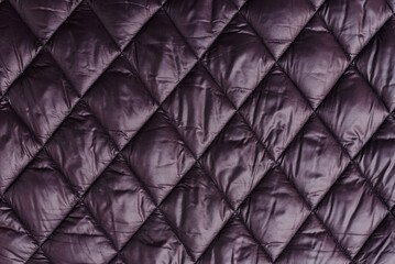 Quilted fabric background texture blanket or puffer jacket.padded, down jacket. Background of urban winter outfit.Quilted pattern.Banner. © ARVD73