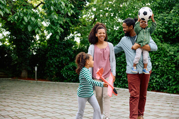 Cheerful black family enjoys in outdoor weekend activities.