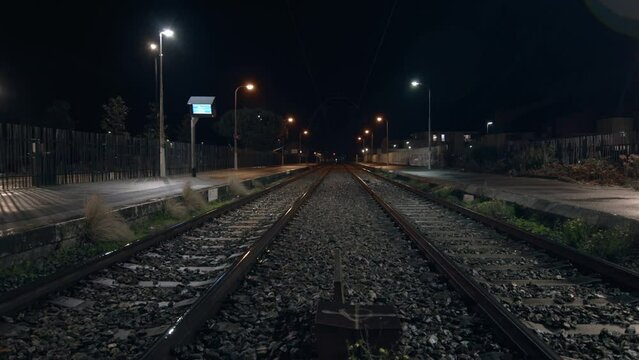Empty train tracks in a rural countryside town at night