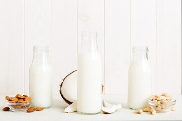 Set or collection of various vegan milk almond, coconut, cashew, on table background. Vegan plant based milk and ingredients, top view