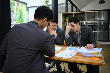 Exhausted business colleagues feel stressed with bad work result or paperwork statistics problem at meeting room