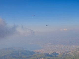 Paragliding in sky. Paraglider tandem flying over sea and mountains in cloudy day. view of paraglider and Blue Lagoon in Oludeniz, Turkey. Extreme sport. Landscape
