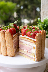 Strawberry tiramisu cake with decorated savoiardi cookies.