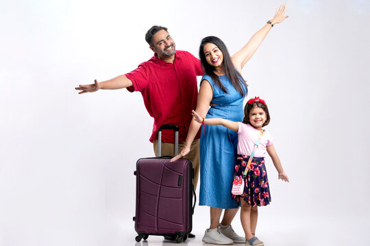 Indian family with luggage on white background.