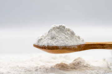 Powdered sugar on wooden spoon. Powdered sugar or icing sugar isolated on white background - obrazy, fototapety, plakaty