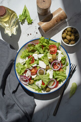 Greek salad with vegetables and cheese on a gray table