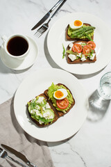 Toasts with egg, avocado and other vegetables on a gray background in a plate. healthy breakfast