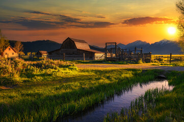 Colorful sunset over Historic John Moulton Barn at Mormon Row in Grand Teton National Park on a...