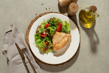 Salad with vegetables and chicken on a gray background
