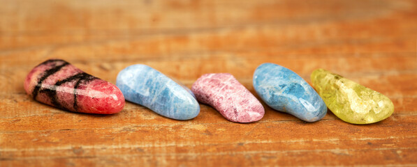 Colorful healing crystal stones on wooden background. Gemstone jewelry banner with copy space.