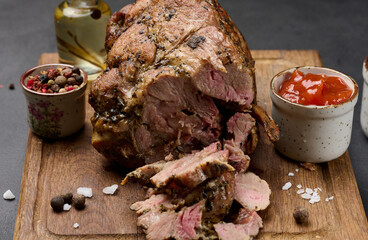 Baked pork collar with spices on a wooden board, delicious and juicy meat