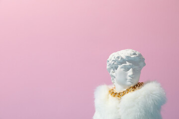 Ancient head in fur against pink background