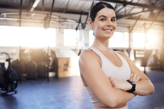 Happy, arms crossed and exercise with a woman at gym for fitness, training workout and strong muscle. Portrait of athlete person with a smile for space, motivation and performance at wellness club