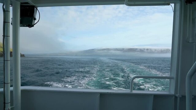 Slowmotion shot of cruising ferry between Faroe island during foggy day
