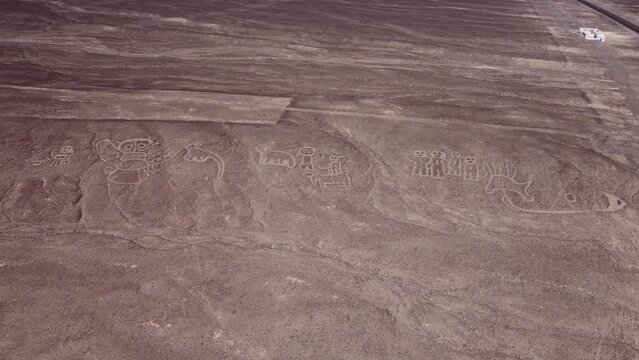 Ancient geoglyphs on the side of a hill, depicting animals and other beings. Drone flies above while slowly turning right. Located in Palpa near the more famous Nazca Lines of Peru.