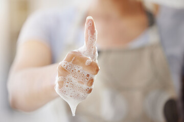 Closeup, soap and person with thumbs up, foam and hygiene with healthy habits, agreement and wellness. Zoom, woman and girl with hand gesture, promotion or daily care with bacteria, clean and bubbles