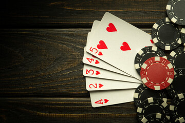 Gambling playing poker with a winning high card combination. Cards with chips on a black vintage...
