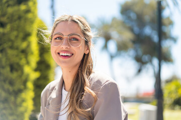 Pretty blonde Uruguayan woman with glasses at outdoors With happy expression - obrazy, fototapety, plakaty