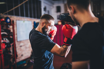 Man on boxing training with instructor on gym