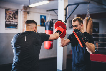 Man on boxing training with instructor on gym