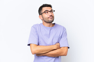 Fototapeta premium Young caucasian man isolated on white background making doubts gesture while lifting the shoulders