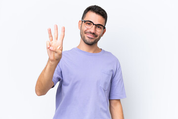 Fototapeta premium Young caucasian man isolated on white background happy and counting three with fingers