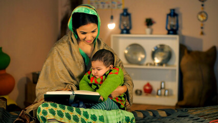A married housewife of a village enjoys reading a book with her adorable son. A pretty female and a...